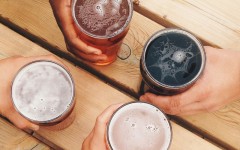 Couples hands with beers on a table while they're on a double date.