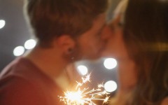 A couple kissing while holding sparklers.
