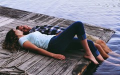 A guy and a girl looking at each other while on a pier.