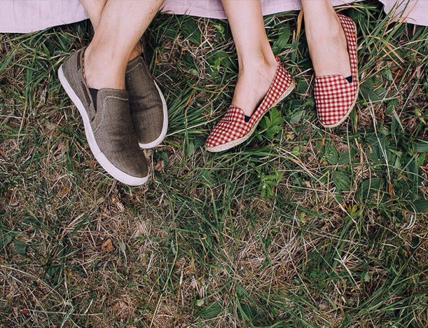 A couple's feet as they lay down on a picnic blanket on a first date.
