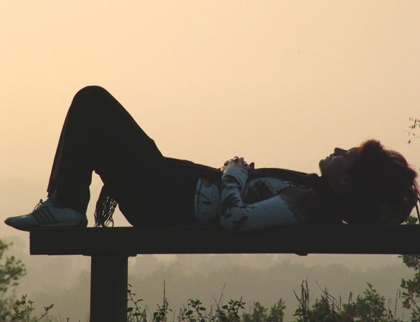 A woman battling depression on a park bench thinking about her relationship problems.