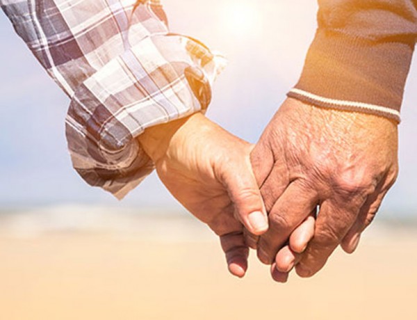 An older couple holding hands because age doesn't matter in their relationship.
