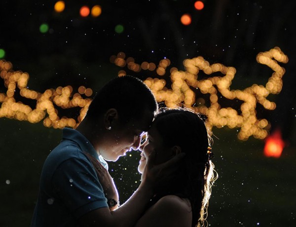 A man and woman at a holiday party looking into each other's eyes.
