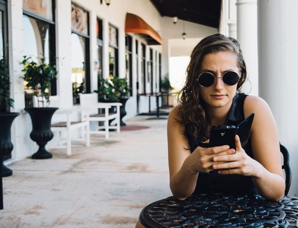 A girl having relationship problems looking mad at her phone.