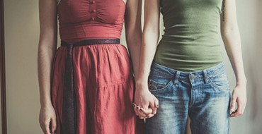 Two women holding hands.