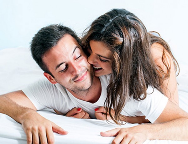 A healthy couple flirting in bed.