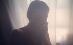 A woman upset in her room because she's going through a breakup.