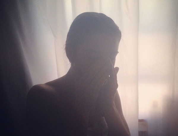 A woman upset in her room because she's going through a breakup.