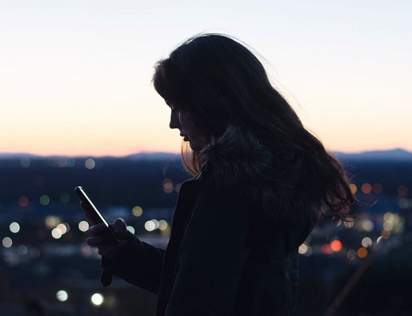 A girl texting while trying to meet someone on an online dating site.