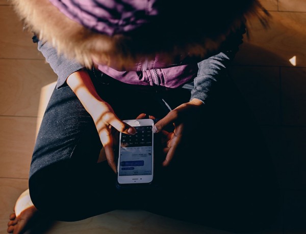 A girl texting while sitting down.