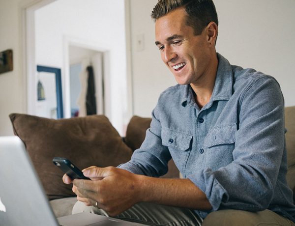 A man using his phone to text someone while using an online dating site.