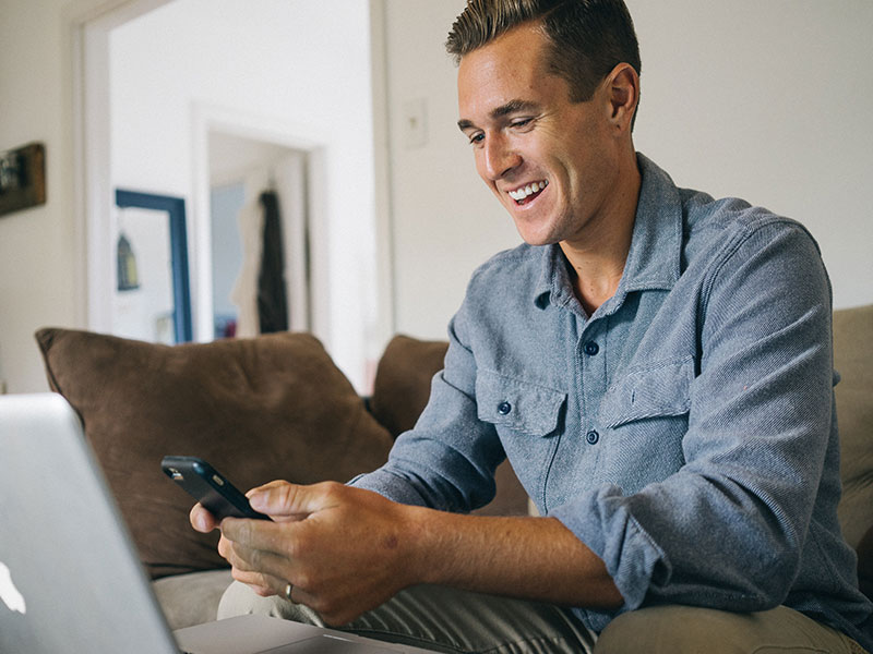 A man using his phone to text someone while using an online dating site.