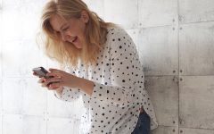 A woman sending flirty texts and laughing.