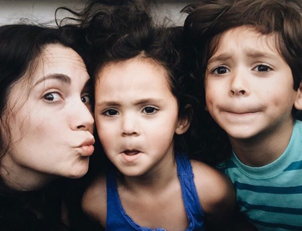 A single parent dating with kids making funny faces with her son and daughter.