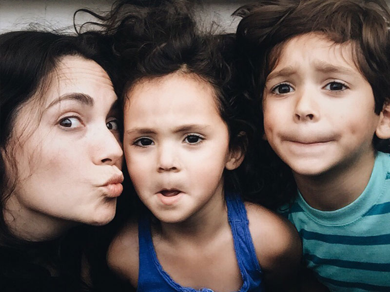 A single parent dating with kids making funny faces with her son and daughter.