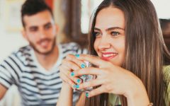 A guy who knows how to ask someone out about to talk to a girl holding a drink.