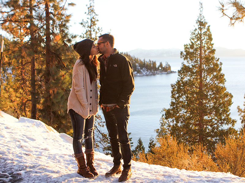 The man kissing a woman in front of a lake took some good relationship advice for men to make her happy.