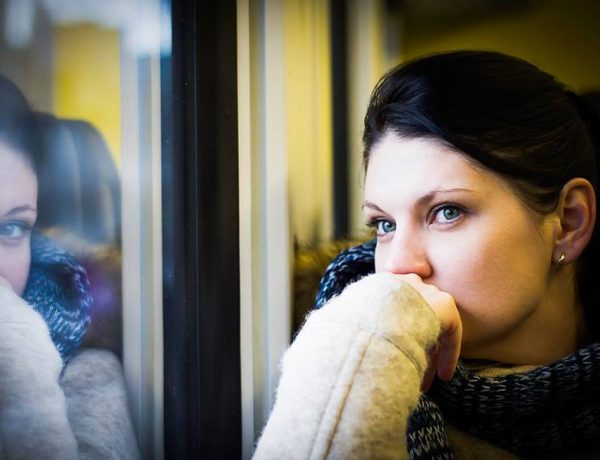 A women wondering how to know when to break up with someone looking out the window and thinking.