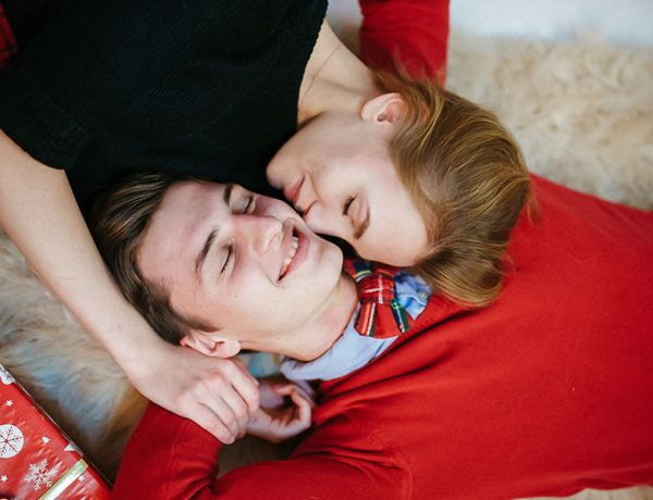 A loving couple cuddling on a blanket during the holidays.