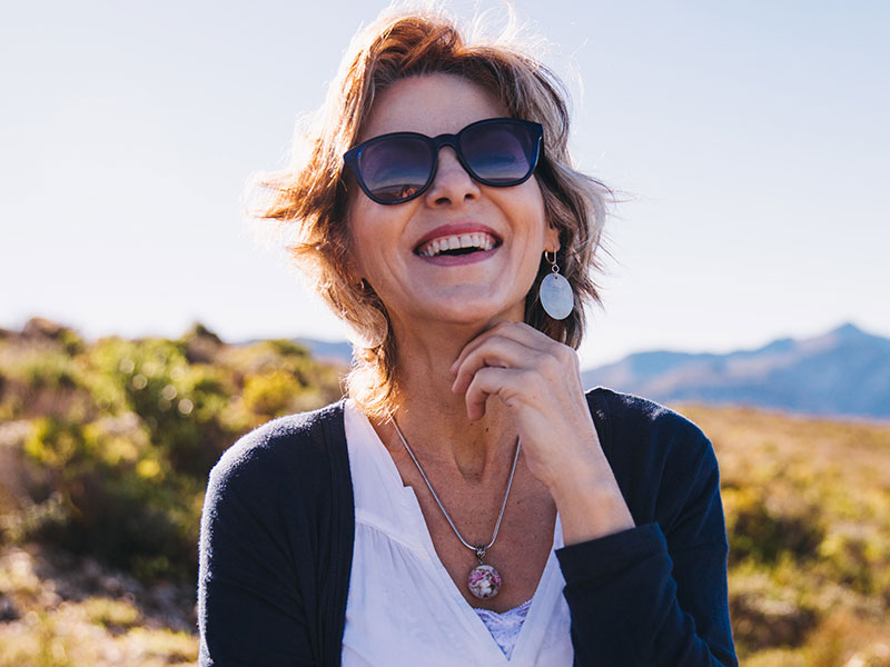 A women laughing because along with other women in their 50s who are dating she likes to enjoy herself.