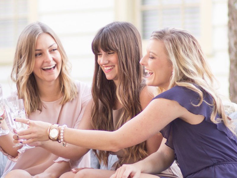 A group of women in their 40s cheersing.