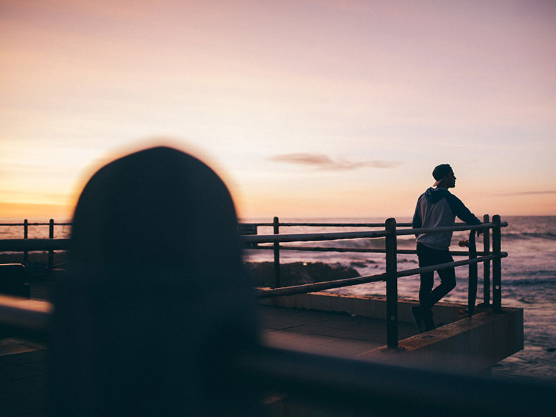 A woman looking at a man in the distance while listening to unrequited love songs.