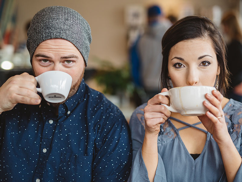 This woman learned how to meet men in real life and now she's sipping coffee with a nice guy at a coffee shop.