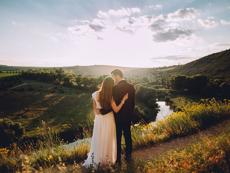 A married couple looking into the sunset at their wedding.