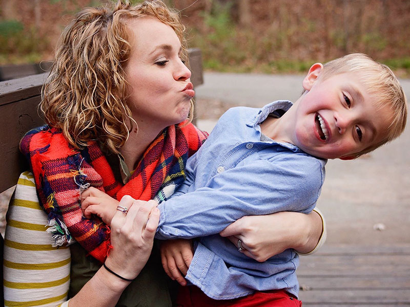 A mom dating as a single parent kissing her kid.