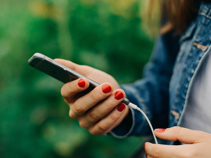 A woman texting a date on her phone using some of these new online dating terms.