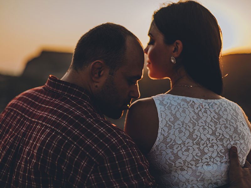 A couple who took this strong relationship advice sitting in the sunset.