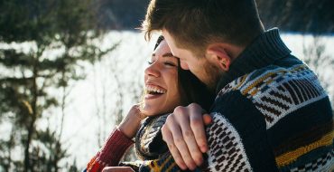 A couple hugging and laughing who learned these dating statistics.