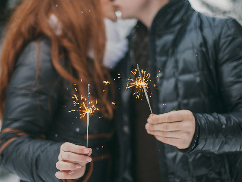 A couple who followed these new dating rules for 2018, kissing in the snow while holding sparklers.