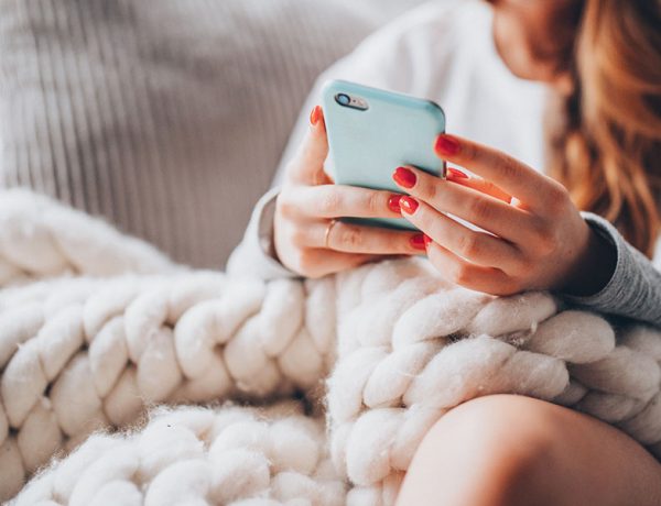 This woman updating her dating profile on her phone used these online dating profile examples to attract men to improve her profile.