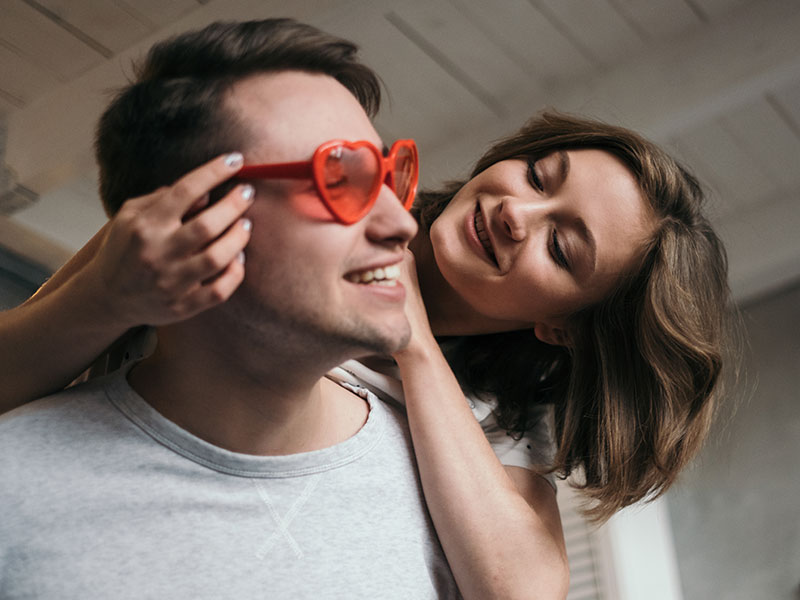 A couple asking each other relationship questions while flirting and laughing.