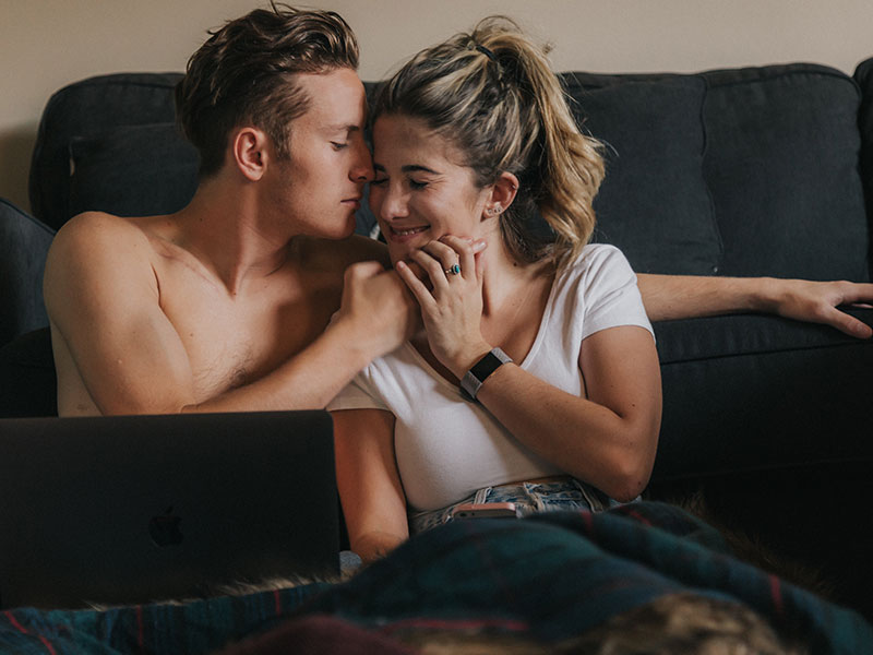 A woman who's afraid she's falling in love too easily, smiling as her boyfriend kisses her forehead.