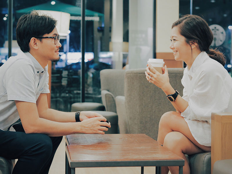 A man and a woman who listened to these speed dating tips laughing and talking while on a speed date.