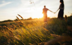 A woman who listened to these dating tips for women over 40 in a field at sunset with her boyfriend.