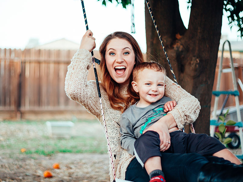 A mom who took this single parent dating advice on a swing with her kid laughing.