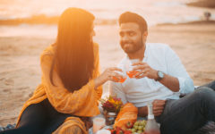 A couple who found what to talk about on a first date, cheersing on the beach.