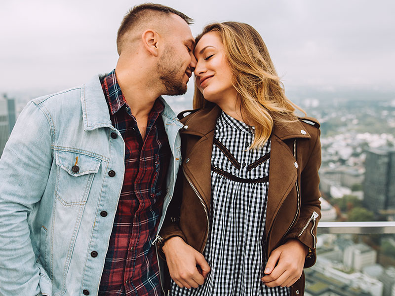 A woman who hasn't learned how to spot a player, closing her eyes as a man kisses her forehead.