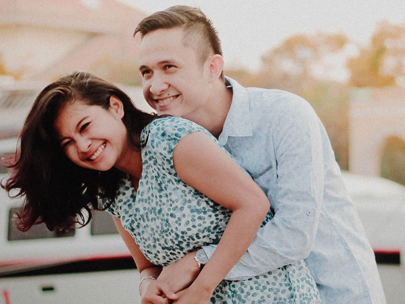 A couple who used to hate dating laughing together in the sunset.