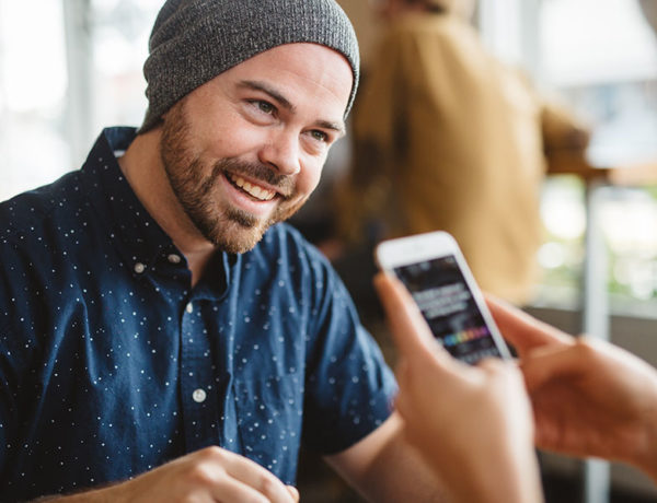 A guy with a woman who's sending him one of these texts guys love to receive, laughing and flirting.