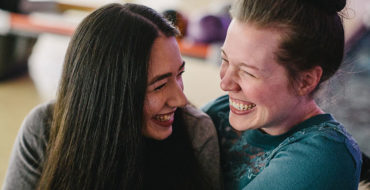 A bisexual woman who often deals with biophobia laughing with another woman she's on a date with.