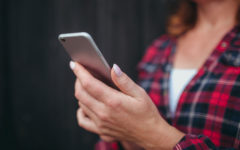 A woman reading Tinder icebreakers who's about to message a man back.