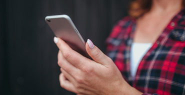A woman reading Tinder icebreakers who's about to message a man back.