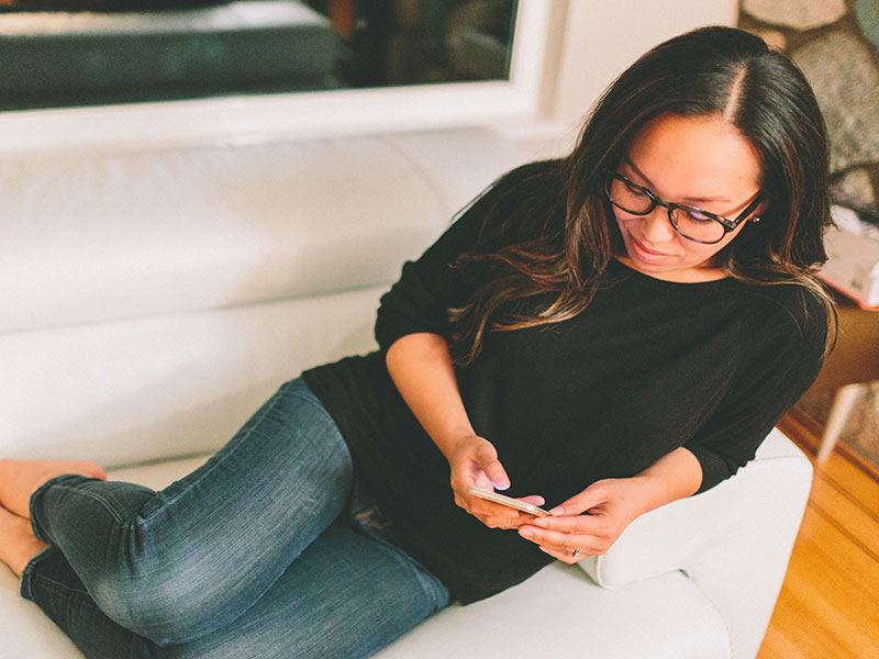 A woman on her phone trying to figure out how Coffee Meets Bagel works.