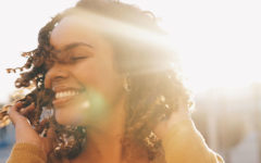 A woman smiling in the sun and enjoying her life after divorce.