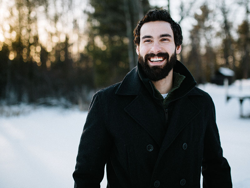 A man who read these dating tips for shy guys smiling confidently in the snow.