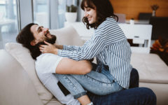 A guy who used one of these flirty quotes for her laughing while his girlfriend sits on his lap and teases him.